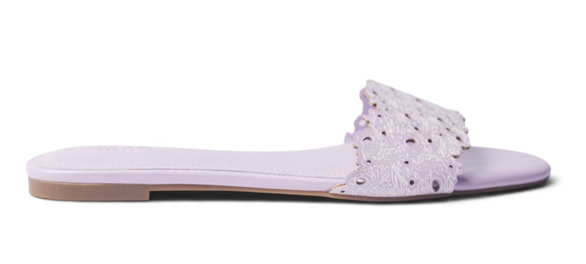 A single lavender flat slide sandal with a decorative cutout strap, shown in profile against a white background.