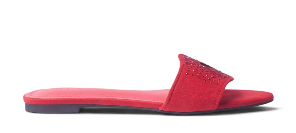 A red slide sandal with a studded strap, shown in a side profile view against a white background.